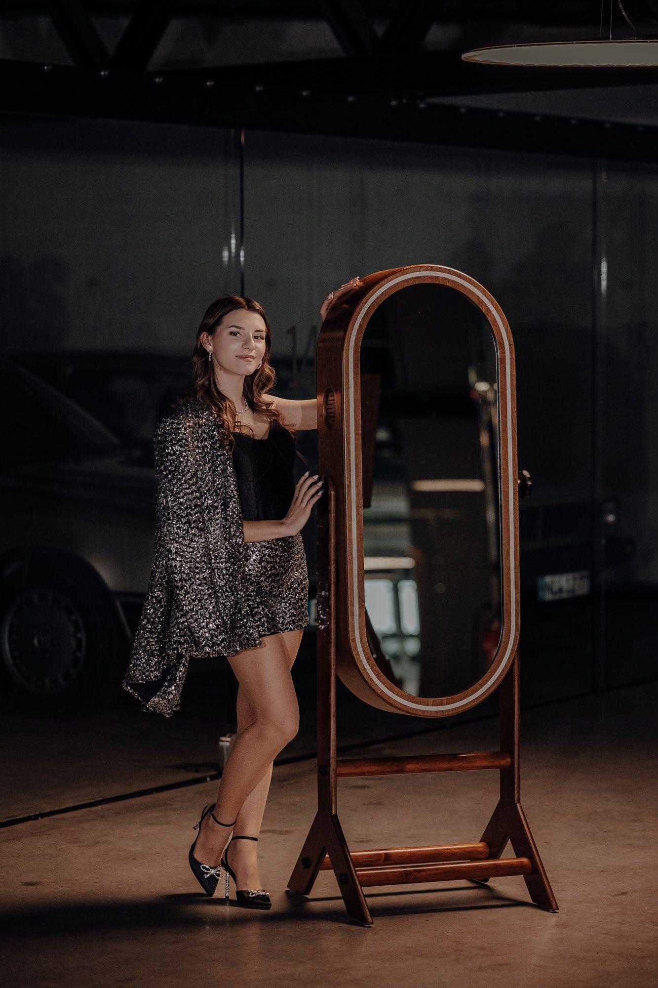 Gast im Glitzerblazer posiert neben der Spiegelbox «Mirror» mit Leuchtring an einer Feier